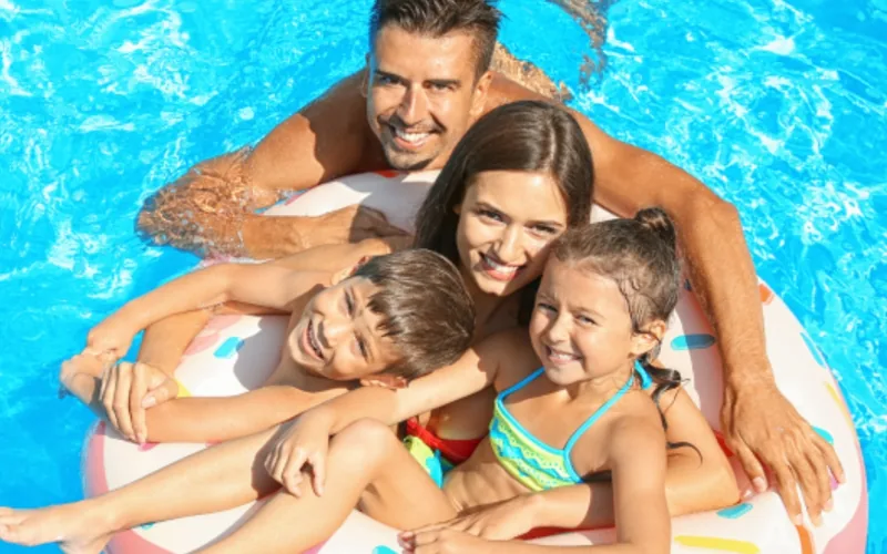 Familia sobre un flotador en la piscina